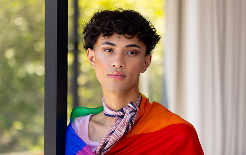 wearing-pride-flag-transgender-transgender-woman-standing-confidently-living-room-1
